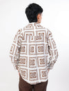Women wearing abrown patterned shirt with a white background