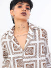 Women wearing a brown patterned shirt with a neutral background