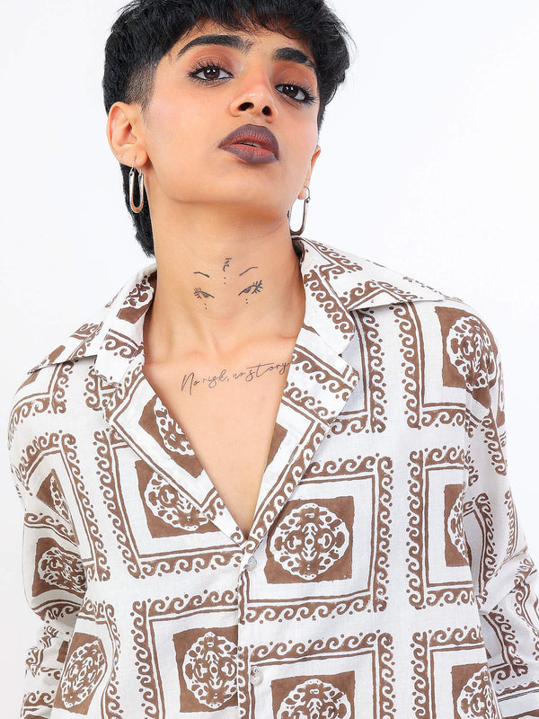 Women wearing a brown patterned shirt with a neutral background