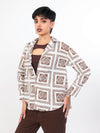 Women wearing a brown patterned shirtand pants on a white background