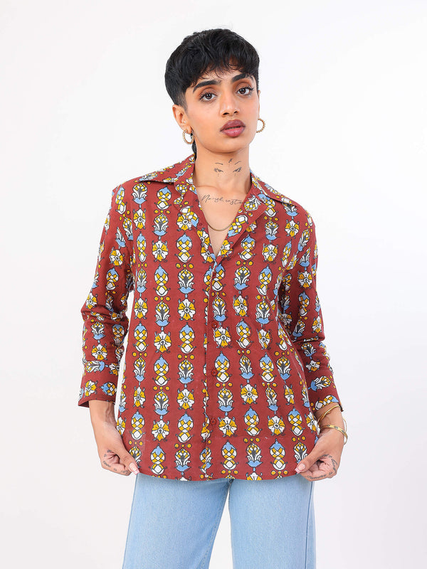 Person wearing a patterned red shirt with a plain background