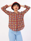Person wearing a patterned red shirt and light blue jeans on a white background
