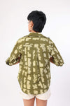 women wearing a green patterned shirt with white shorts on a white background