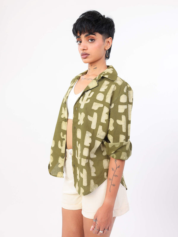 women wearing a green patterned shirt with white shorts on a white background