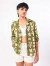 women wearing a green patterned shirt with white shorts on a white background