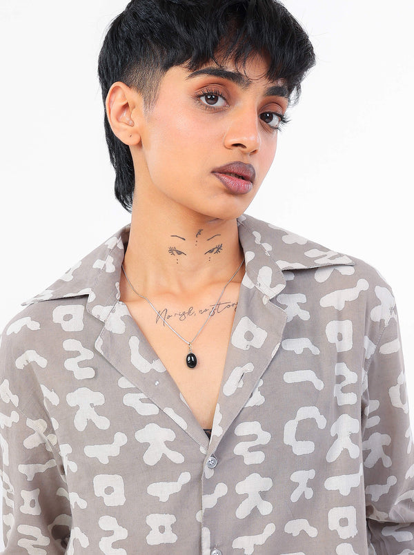 Person wearing a patterned shirt with a neutral background