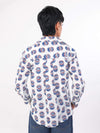 Women wearing a evil eye patterned shirt with blue jeans on a white background