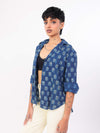 Woman wearing a indigo patterned shirt on a white background