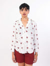 Women wearing a white ocean print shirt and red shorts on a white background
