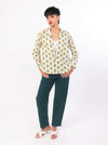 Woman wearing a Sun & Leaf shirt and green pant on a white background