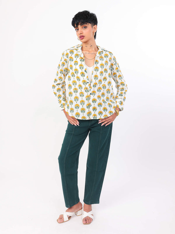 Woman wearing a Sun & Leaf shirt and green pant on a white background