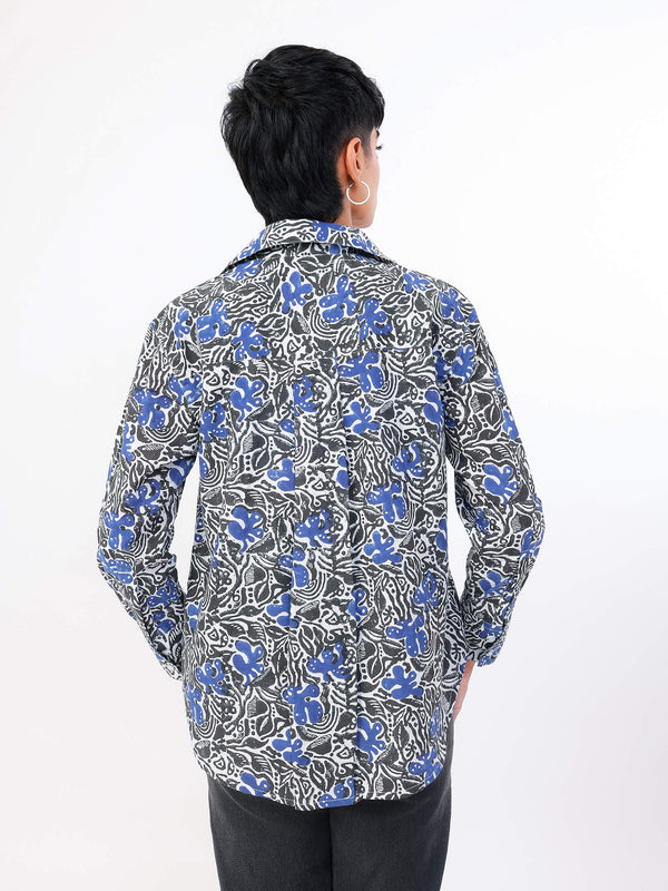 Person wearing a blue and white floral patterned shirt on a white background