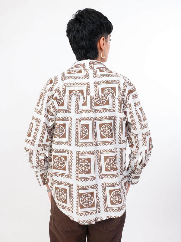 Women wearing abrown patterned shirt with a white background