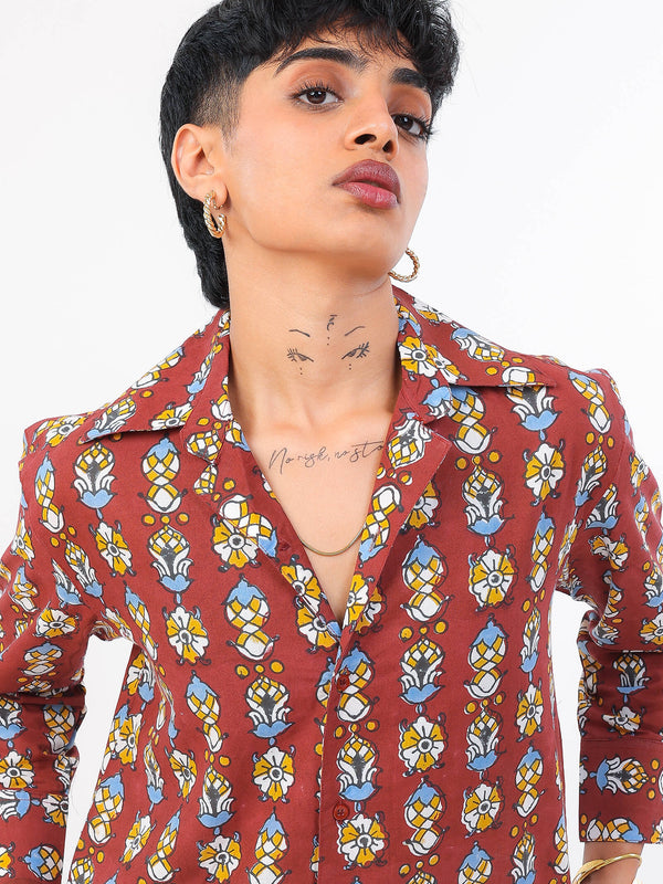 Woman wearing a red patterned shirt against a white background