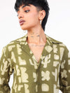 Women wearing a green patterned shirt against a white background