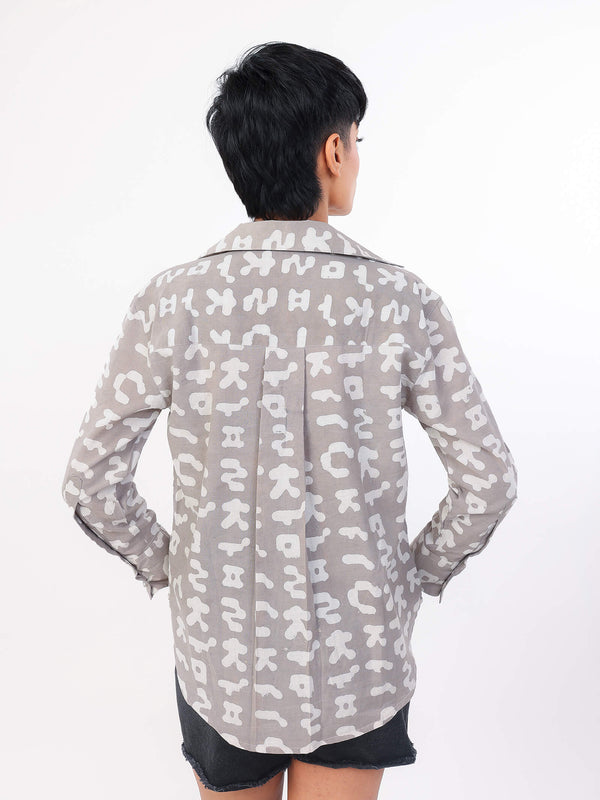 Person wearing a patterned shirt on a white background