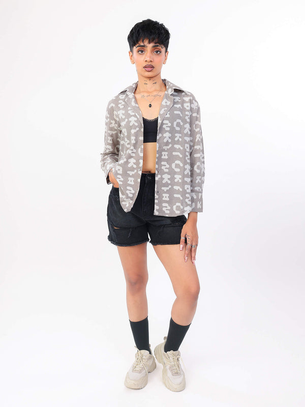 Person wearing a patterned shirt, black shorts, and white sneakers on a white background