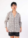 Person wearing a patterned shirt with a plain background