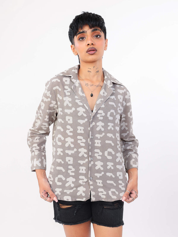 Person wearing a patterned shirt with a plain background