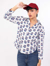 Woman wearing a evil eye patterned shirt and red cap on a white background