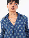 Women wearing a indigo patterned shirt against a white background