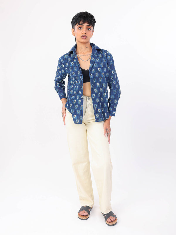 Women wearing a indigo patterned shirt and beige pants on a white background