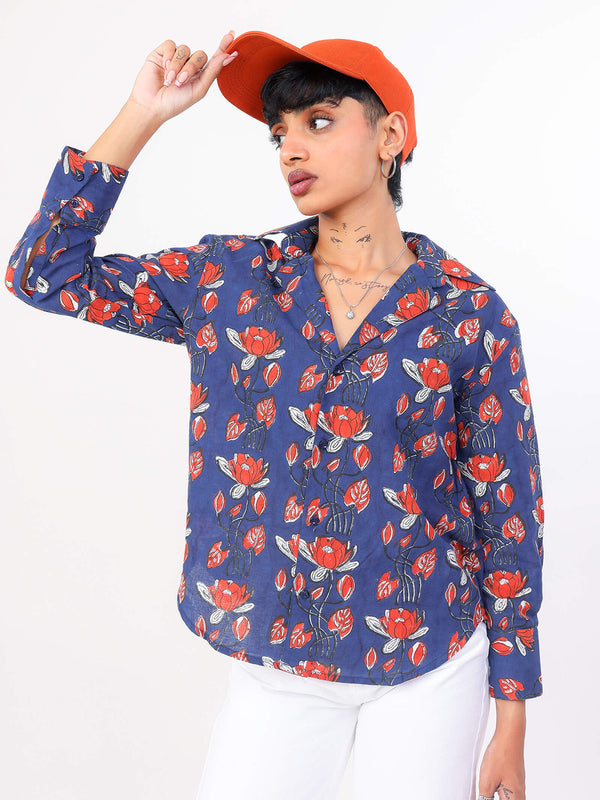 Women wearing a blue floral shirt with orange flowers and an orange cap on a white background