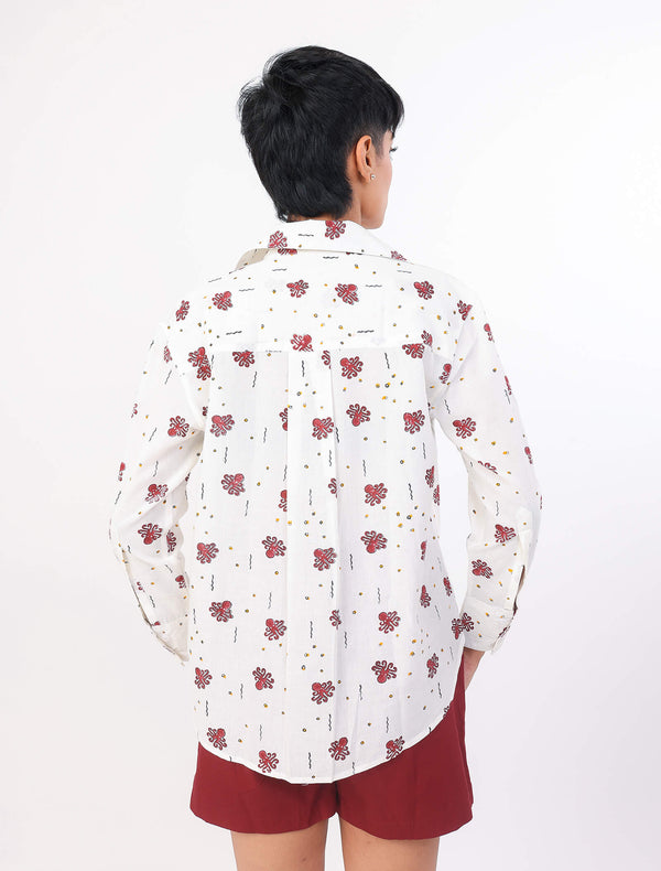 Person wearing a white ocean print shirt and red shorts on a white background